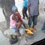 A woman making grilled corn outside of the Faculty of Sciences campus.